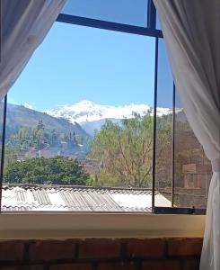 a window with a view of snow covered mountains at Munay Wasy Carhuaz in Carhuaz