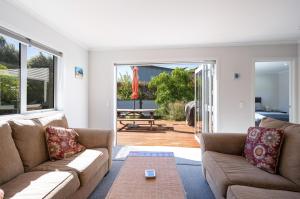 a living room with two couches and a patio at Pohara Retreat in Pohara