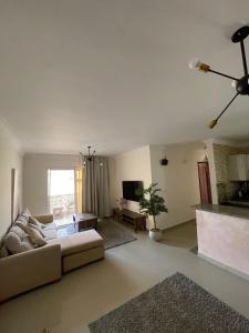 a living room with a couch and a table at شقه في مدينتي غرفتين و صاله مكيفه مفروشه فندقي - Fully Furnished & Air-Conditioned 2-Bedroom Apartment with Large Living Room in Madinaty - 98 sqm in Madinaty