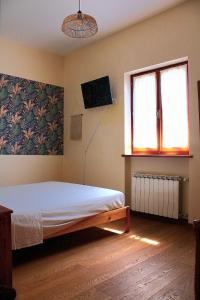 a bedroom with a bed and a tv and a window at B&B Tramonti sull'Adriatico in Muggia