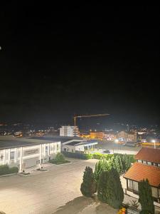a large building with a parking lot at night at Apartman Galić Posušje in Posušje
