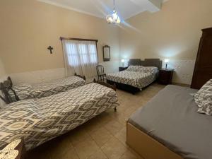 a bedroom with two beds and a cross on the wall at CASA NONI in Salta