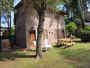 a house with a picnic table and a tree at Los Cabre in San Pedro