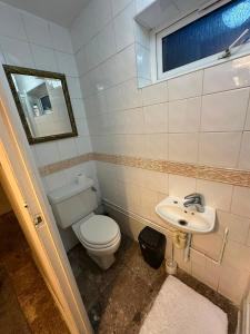 a bathroom with a toilet and a sink at Heathrow Ensuite in West Drayton