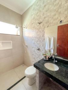 a bathroom with a toilet and a sink at Casa Doce Lar 2 in Uberaba