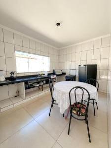 a kitchen with a table and two chairs in it at Casa Doce Lar 2 in Uberaba