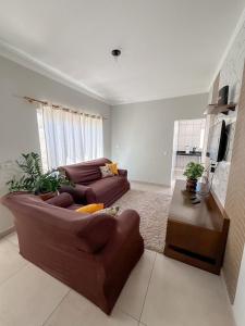 a living room with two couches and a tv at Casa Doce Lar 2 in Uberaba +5 photos