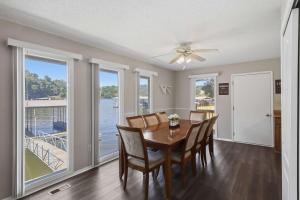 a dining room with a table and chairs and windows at Private Dock-Deck-LakeHouse-Lake Front-3bd 2bth in Lake Ozark