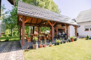 a wooden pavilion with potted plants in a yard at Apartment Smoljanac 14979a in Smoljanac
