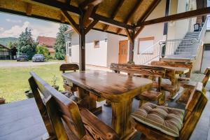a wooden table and chairs on a patio at Apartment Smoljanac 14979a in Smoljanac