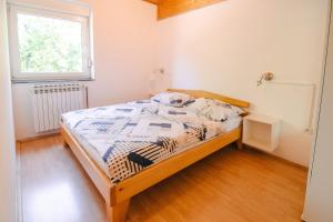 a bedroom with a bed and a window at Apartment Smoljanac 14979a in Smoljanac