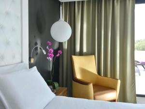 a bedroom with a bed and a chair at Pullman Mazagan Royal Golf & Spa in El Jadida +273 photos
