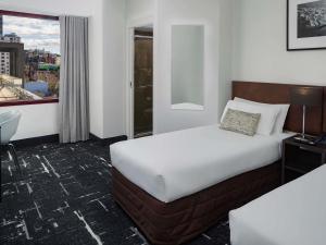 a hotel room with a bed and a window at Mercure Melbourne City Centre in Melbourne +52 photos