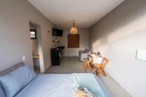 a bedroom with a bed and a table and a couch at Casa Jabu in Catas Altas