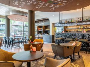 a restaurant with tables and chairs and a bar at ibis Amsterdam Centre Stopera in Amsterdam