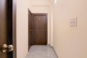 a hallway with a door and a room with a bed at Super Collection O Gariahat Kolkata Formerly 6 Seasons in Kolkata +26 photos