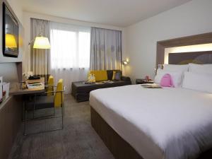 a hotel room with a large bed and a couch at Novotel Leuven Centrum in Leuven +97 photos