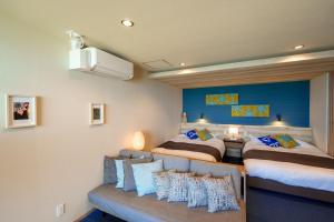 a bedroom with two beds and a couch at THE SHIKAKA Hotel&Resort BUDOUNOKI in Itoshima