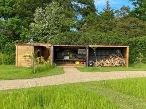 a shed with a pile of wood in it at Bunkers Hill Farm in Bramfield