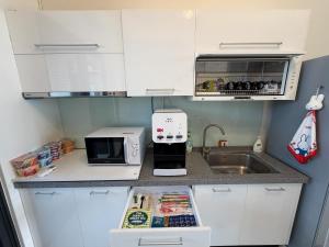 a small kitchen with a sink and a microwave at 捌之捌民宿 in Nan-ho-ts'un +2 photos