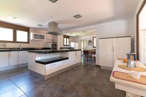a large kitchen with white cabinets and a table at NorthStyle by Fidalsa in Lanestosa