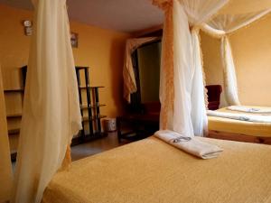 a bedroom with two beds with white drapes at Scenic View Hotel and Resort in Thika +30 photos