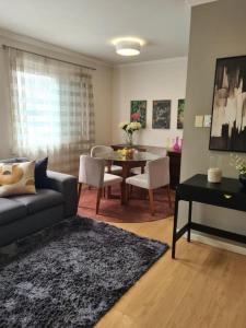 a living room with a couch and a table at Ap Central 3 quartos com elevador e garagem in Pelotas