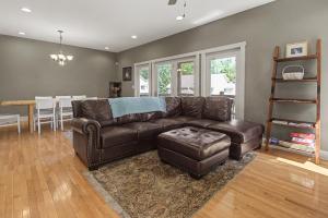 a living room with a brown leather couch and a table at Gulfway Hideaway in Oakland