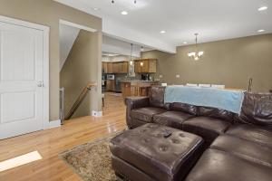 a living room with a brown leather couch and a kitchen at Gulfway Hideaway in Oakland +34 photos