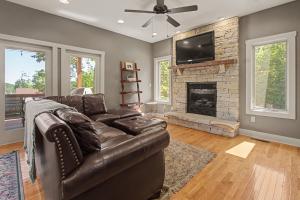 a living room with a leather couch and a fireplace at Gulfway Hideaway in Oakland