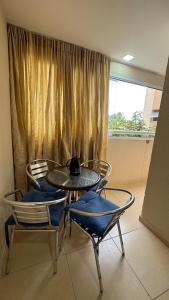 a table and chairs in a room with a window at Horto da Barra - Apartamento à Beira Mar in Barra dos Coqueiros