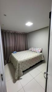 a bedroom with a bed with a blanket on it at Horto da Barra - Apartamento à Beira Mar in Barra dos Coqueiros
