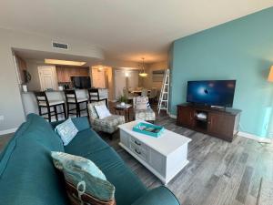 a living room with a blue couch and a flat screen tv at A Wave From it All in Destin
