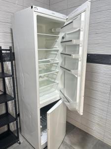 an empty refrigerator with its door open in a room at Apartment Luxueux a Cité Apix in Niadyorane