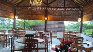 a restaurant with tables and chairs and windows at Nan Bungalows Tetebatu in Tetebatu