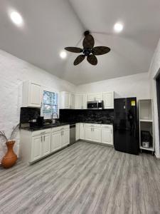 a kitchen with a ceiling fan and a black refrigerator at CASA BOHEMIA - Resort de Cerveza y vino in Campoalegre