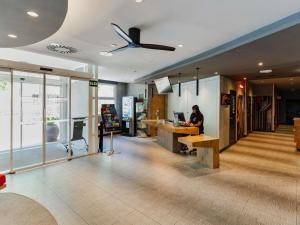a woman sitting at a desk in an office at Ibis Barcelona Castelldefels in Castelldefels