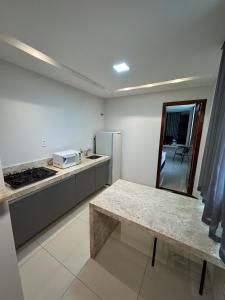 a kitchen with a table and a counter top at Hotel Califórnia in Canindé +15 photos