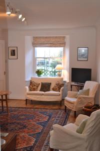 un soggiorno con 2 divani bianchi e una TV di St Louan's ad Alyth
