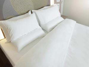a white bed with white pillows on it at Novotel Leeds Centre in Leeds +113 photos