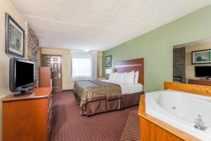 a hotel room with two beds and a television at Baymont by Wyndham Pigeon Forge near Island Drive in Pigeon Forge