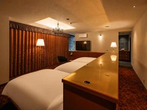 a hotel room with two beds and a television at ホテル寺町亘hotel teramachi watari in Matsue