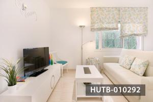 - un salon blanc avec un canapé blanc et une télévision dans l'établissement Apartamento Roca Mar, à Sitges