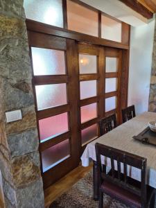 a dining room with a table and a stone wall at Family Apartments in Žabljak
