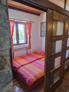 a bedroom with a bed and a window at Family Apartments in Žabljak