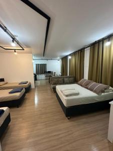 a large room with two beds and a couch at Kitnets do Supermercado Simples Luxo e Deluxe! in Limeira