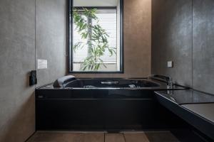 a bathroom with a bath tub with a window at ホテル寺町亘hotel teramachi watari in Matsue +39 photos
