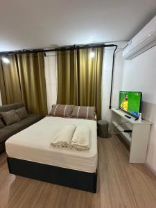 a bedroom with a bed and a desk with a computer at Kitnets do Supermercado Simples Luxo e Deluxe! in Limeira