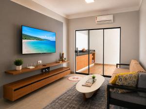 a living room with a couch and a tv on a wall at Conforto e praticidade em um só local in Rio Verde