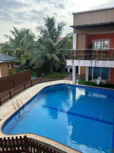 a large blue swimming pool in front of a building at Villa Char in Accra